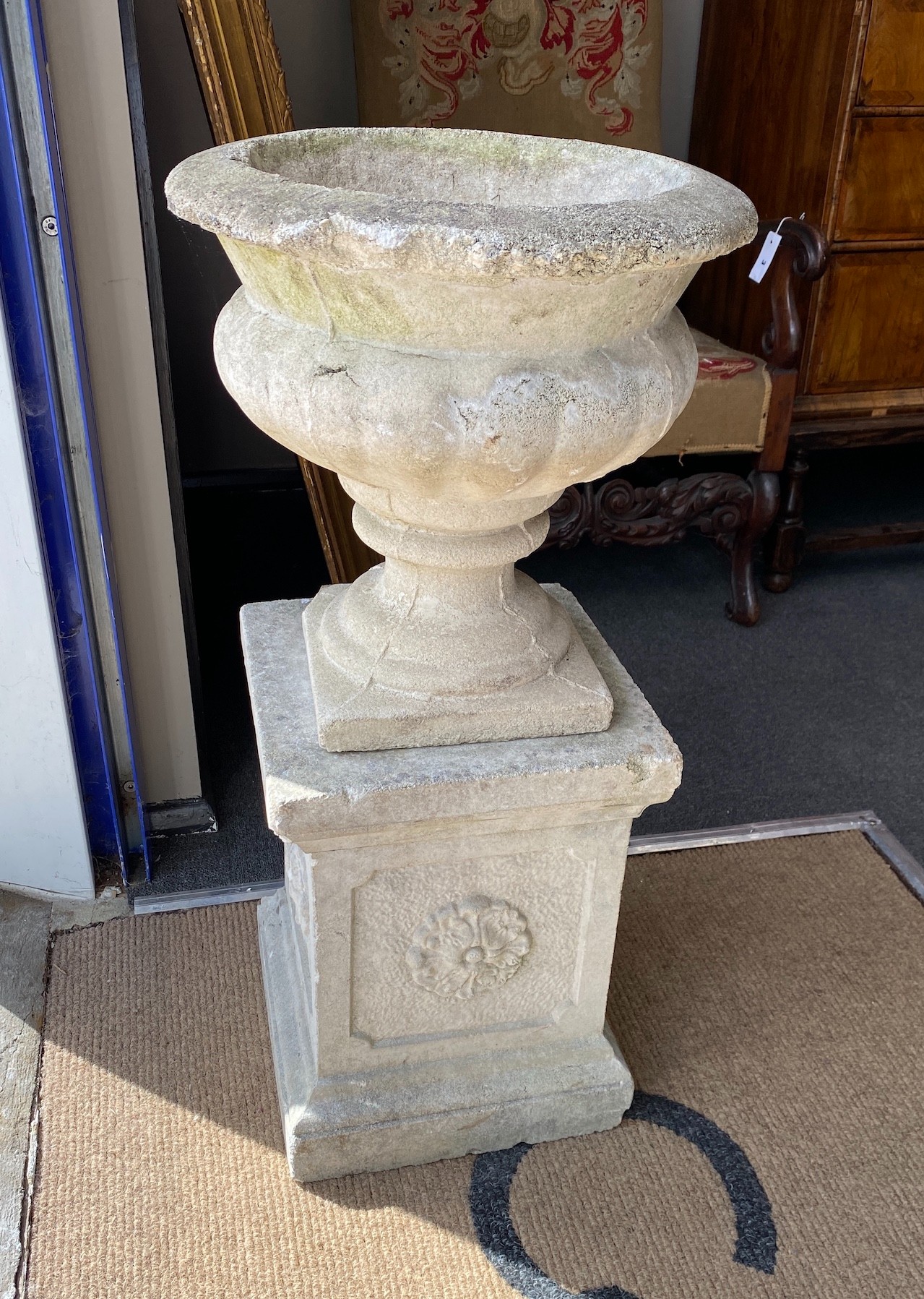 A pair of reconstituted stone campana garden urns on a near pair of square pedestals, larger height 86cm